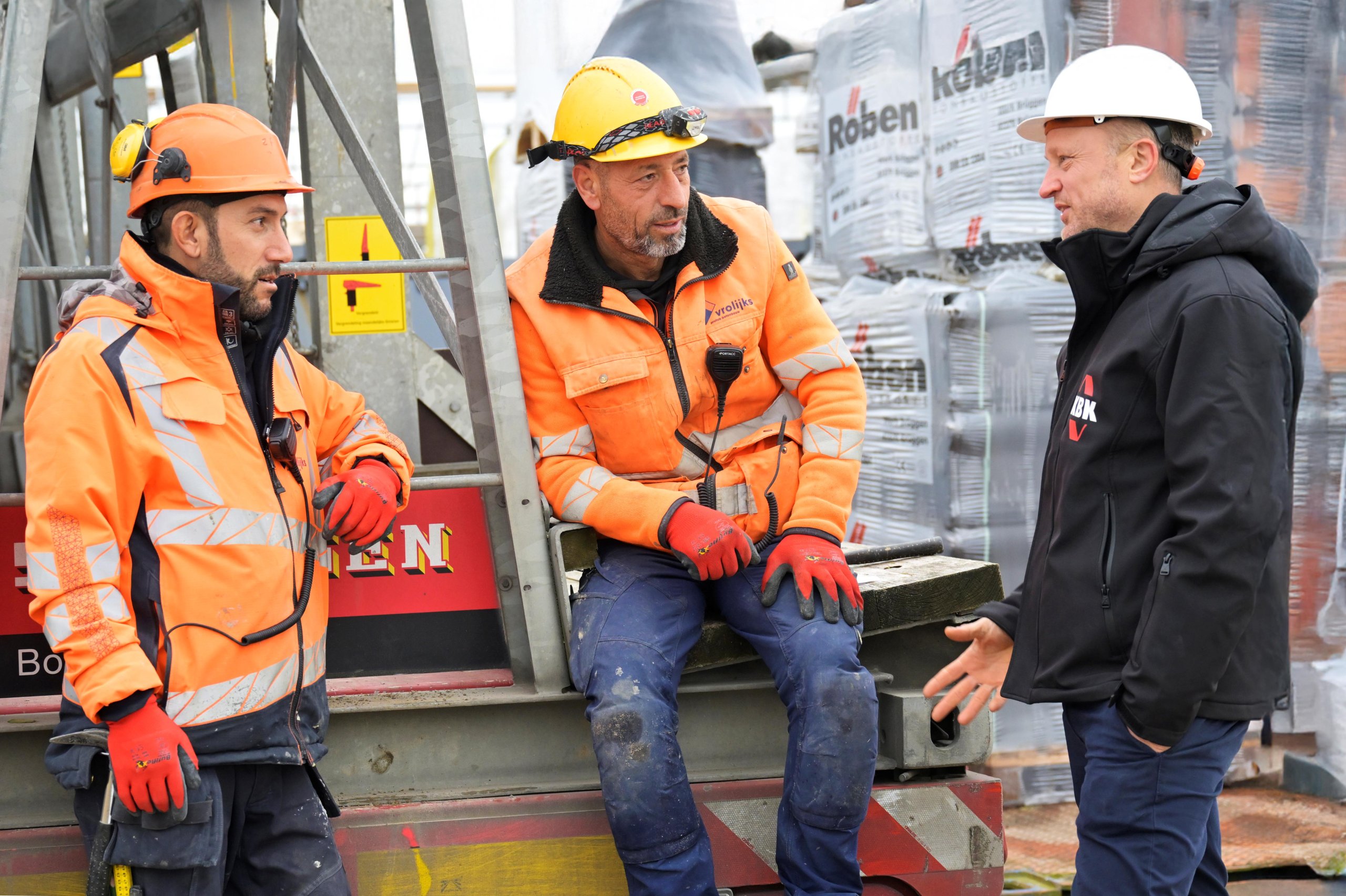 Hoofd Inkoop KBK bouwgroep in overleg met onderaannemers lachend